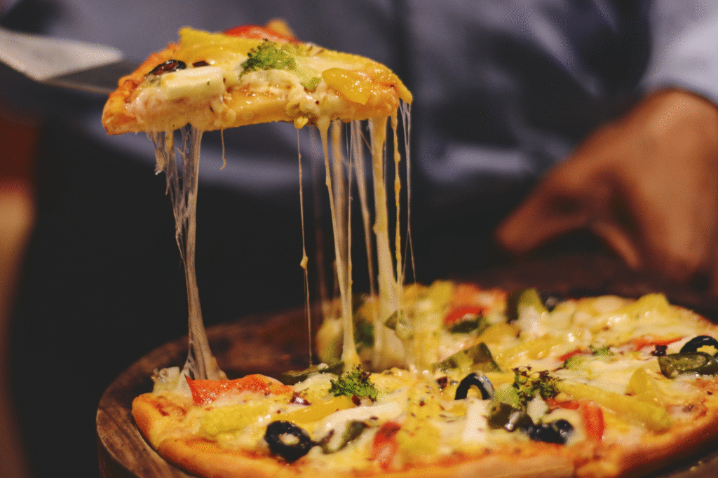 Pedaco-de-pizza-com-queijo-sendo