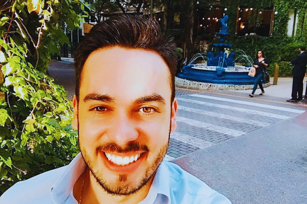 homem-pousando-para-foto-na-rua-avanhadava-com-fonte-de-agua-ao-fundo